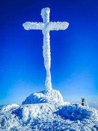 Summit cross in winter with blue sky