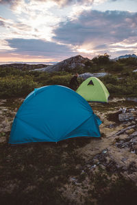 Camper opening tent in cloudy sunset