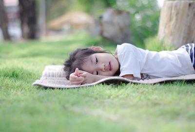 Cute girl lying on picnic blanket at park