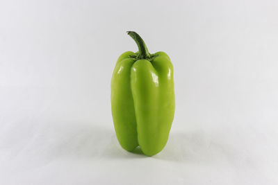 Close-up of green chili pepper against white background