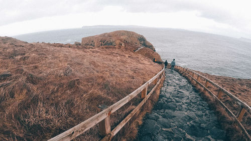 Scenic view of mountain by sea against sky