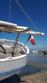 Sailboat moored on sea against clear blue sky