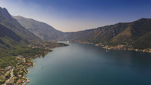 Scenic view of river and mountains against clear blue sky