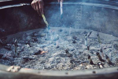 Cropped hands of people burning paper