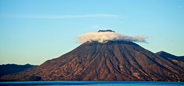 Smoke emitting from volcanic mountain against sky