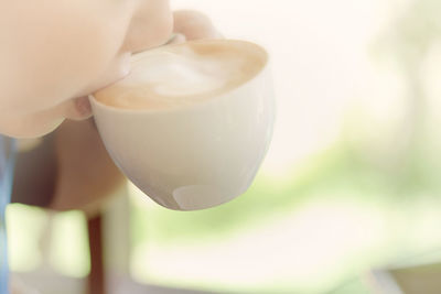 Close-up of hand holding coffee cup