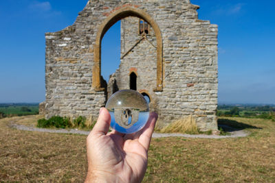 Person holding a lensball against a church 