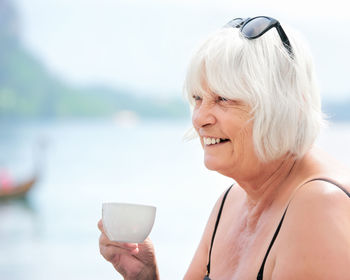 Close-up of smiling senior women holding coffee cup