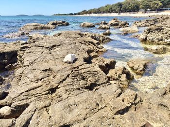 Rocks on beach against sky