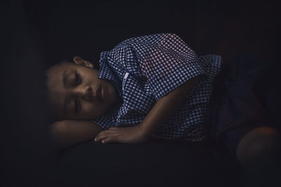 Close-up of boy sleeping on sofa at home