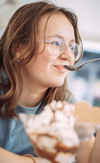 Close-up of young woman blowing ice cream