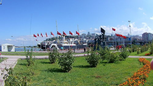 Panoramic view of people at park against buildings