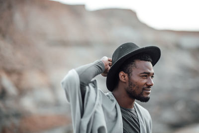 Portrait of young man looking away outdoors