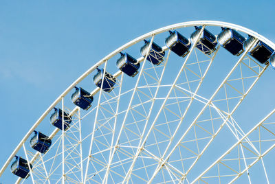 Low angle view of ferris wheel against blue sky