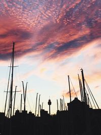 Low angle view of silhouette sailboat masts against sky during sunset