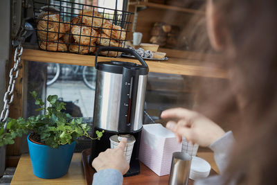 Cropped image of saleswoman using coffee machine in food truck