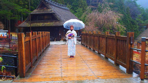 Woman standing on footbridge in rain