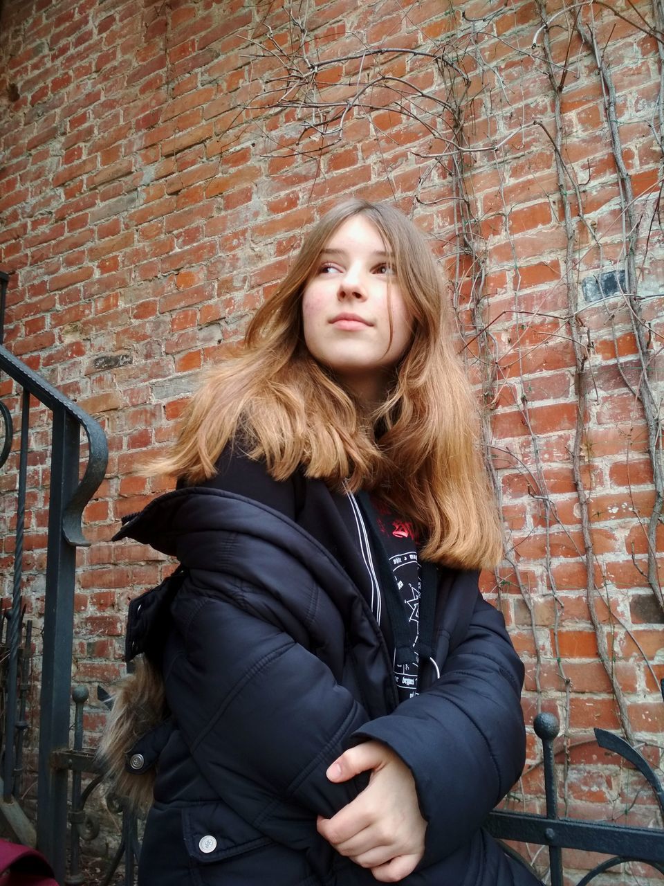 brick wall, hair, brick, one person, wall, long hair, wall - building feature, hairstyle, young adult, real people, lifestyles, blond hair, young women, leisure activity, front view, architecture, portrait, jacket, beautiful woman, warm clothing, teenager, outdoors, leather