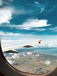 Airplane flying in sky seen through glass window