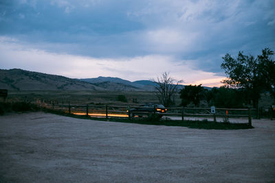 Scenic view of road by mountains against sky