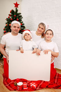 Portrait of happy family with big big white empty banner for text