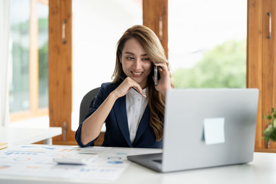 Young businesswoman using laptop at office