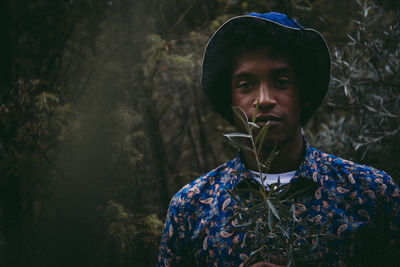 Portrait of young man looking away in forest