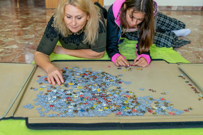 Friends playing jigsaw puzzle