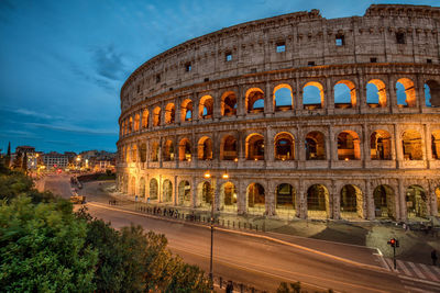 Illuminated roman colosseum against the dusk sky.