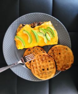 High angle view of an omelet and waffles in plate on table