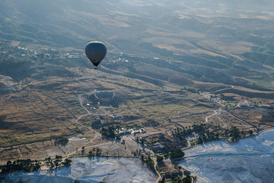 Aerial view of hot air balloon flying over landscape