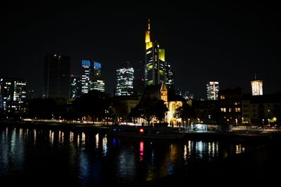 Illuminated buildings against sky at night