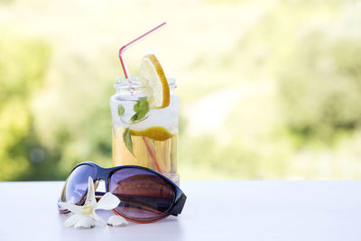 Close-up of sunglasses and drink on table