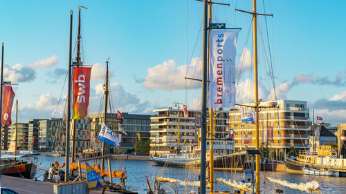 Sailboats in harbor against sky