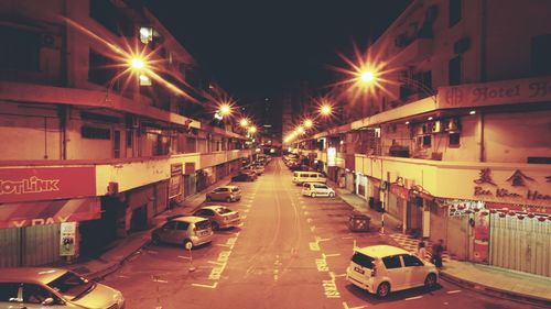 Cars on illuminated road in city at night