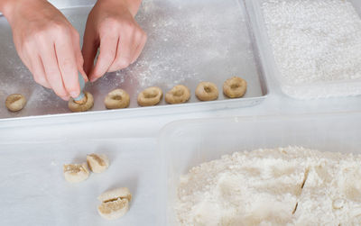 Cropped hands of person making cookies on baking sheet