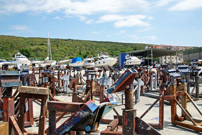 Rusty metal parts at harbor against sky