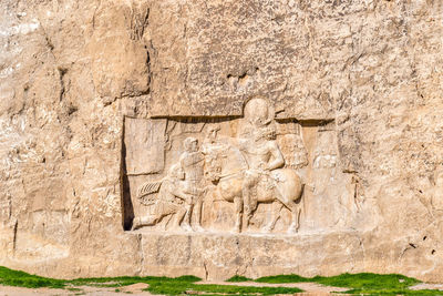 Close-up of old statue against wall