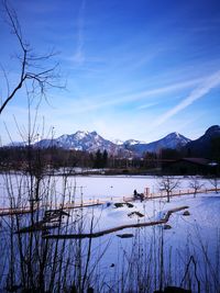 Scenic view of lake and mountains against sky during winter