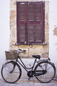 Bicycle leaning against wall of building