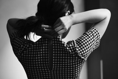 Rear view of woman wearing checked pattern clothes