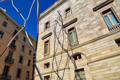 Low angle view of buildings against clear blue sky