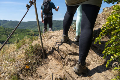 A woman walking a trail through the vineyards on a rocky,slate surface in specialized climbing shoes