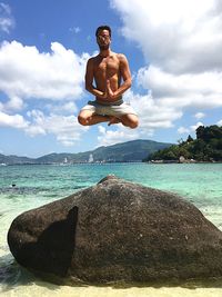 Man levitating against sea at beach