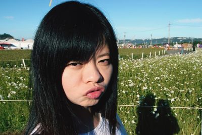 Close-up portrait of young woman in field