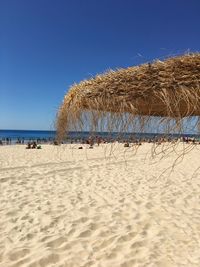 Scenic view of beach against clear blue sky