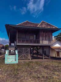 Exterior of old house on field against sky