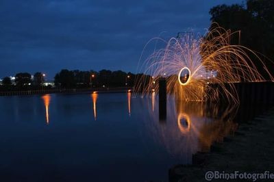 Light painting by lake against sky at night