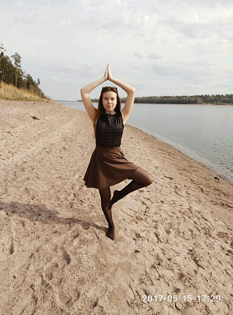 full length, young adult, young women, one person, arms raised, sky, day, front view, beach, leisure activity, casual clothing, outdoors, looking at camera, real people, sand, nature, cloud - sky, portrait, lifestyles, beautiful woman, happiness, beauty in nature, vacations, smiling, water, people