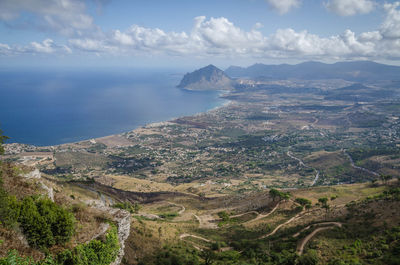 Aerial view of city by sea against sky